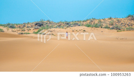 Bright blue cloudy sky over the yellow desert of Kyzylkum Kazakhstan. Rainy weather in the desert. Beautiful landscape of the desert of Central Asia 100953263