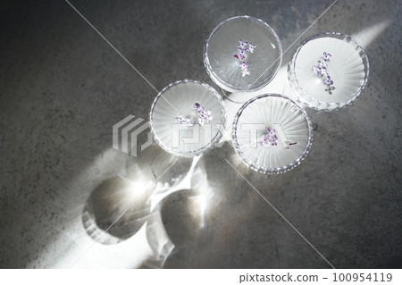 Four glasses with champagne on a light table surface reflecting soft sunshine rayson Four glasses with champagne on a light table surface reflecting soft sunshine rayson 100954119
