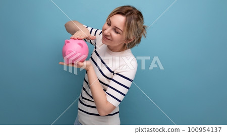 horizontal photo of attractive young woman in casual outfit cute hugging a piggy bank of coins on a horizontal photo of attractive young woman in casual outfit cute hugging a piggy bank of coins on a 100954137