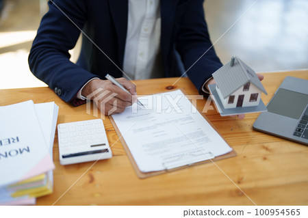 Guarantee, Mortgage, agreement, contract, Signing, Male client holding pen to reading agreement document to sign land loan with real estate agent or bank officer. Guarantee, Mortgage, agreement, contract, Signing, Male client holding pen to reading agreement document to sign land loan with real estate agent or bank officer. 100954565