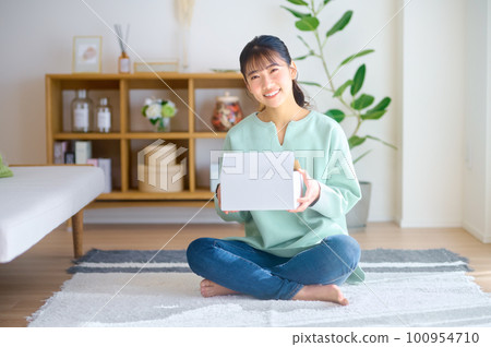 年輕女子在房間裡檢查郵購行李 100954710