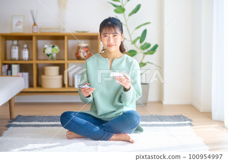 A young woman making a cashless payment using a smartphone 100954997