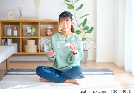 A young woman making a cashless payment using a smartphone 100954998