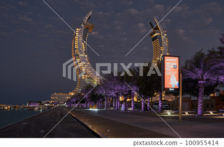 Katara Hospitality Tower, Crescent Tower, or Lusail Katara Hotel North Tower  in Lusail city, Qatar at dusk showing the unique architecture of the illuminated tower with Lusail marina  100955414