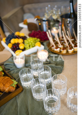 Swiss table at the party. Close up of croissants with greens and glasses with drinks 100955433