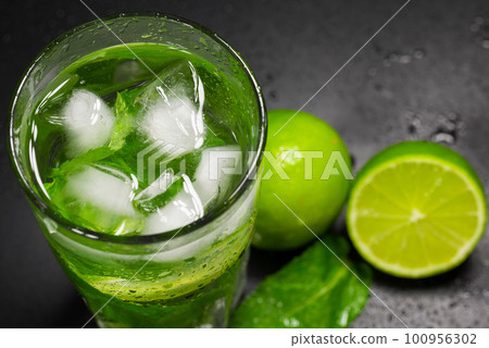 Refreshing lemonade with ice, mint and lime, closeup. Non-alcoholic cocktail Refreshing lemonade with ice, mint and lime, closeup. Non-alcoholic cocktail 100956302