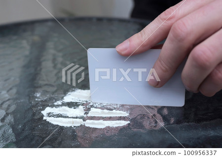 Dose of drugs and the hand of an addict, close-up. Addiction concept 100956337