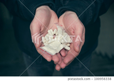 Drugs in the hands of an addict, close up. Addiction concept Drugs in the hands of an addict, close up. Addiction concept 100956338