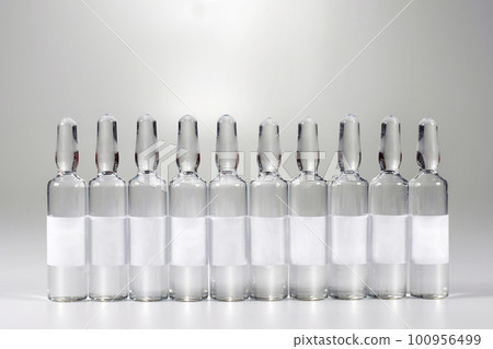 Row of medical ampoules with medicine, on a gray background. Vaccination and Immunization. Row of medical ampoules with medicine, on a gray background. Vaccination and Immunization. 100956499