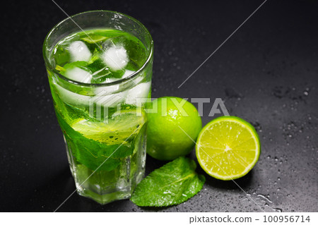 Mojito, lime and mint on a dark background. A refreshing cocktail in close-up 100956714