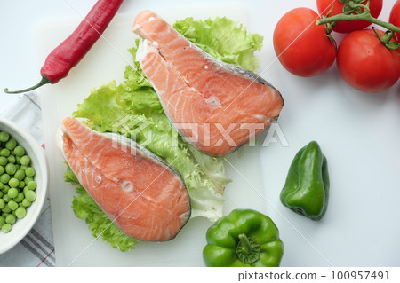 Raw, fresh salmon steak and vegetables on white  100957491