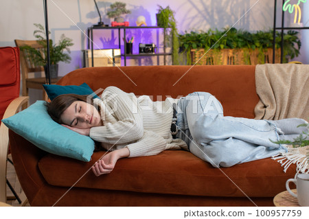Tired young woman girl lying down in bed taking a rest at home, napping, falling asleep on sofa Tired young woman girl lying down in bed taking a rest at home, napping, falling asleep on sofa 100957759