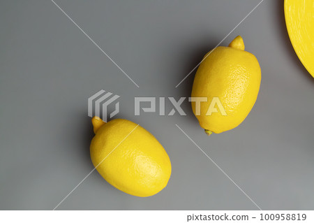Yellow lemons on gray background. Colors of the Year 2021 Illuminating and Ultimate gray. Flat lay. Copy space Yellow lemons on gray background. Colors of the Year 2021 Illuminating and Ultimate gray. Flat lay. Copy space 100958819