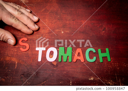 STOMACH Concept. Text from colorful alphabet letters on a painted wooden background STOMACH Concept. Text from colorful alphabet letters on a painted wooden background 100958847