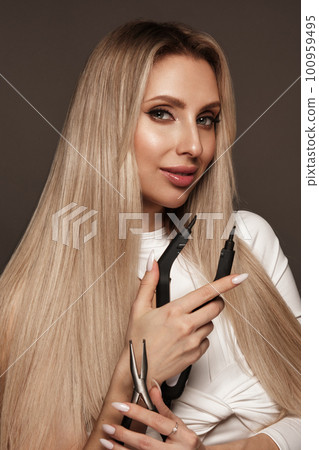 Beautiful blond girl with a perfectly hair, and classic make-up with a strand of hair for extension. Beauty face and hair. Beautiful blond girl with a perfectly hair, and classic make-up with a strand of hair for extension. Beauty face and hair. 100959495