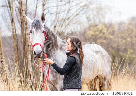 andalusian pure spanish horse. hispanic middle aged woman from horse riding school. equitation andalusian pure spanish horse. hispanic middle aged woman from horse riding school. equitation 100959791