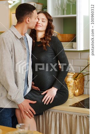 happy and in love man and pregnant woman in black dress. happy and in love man and pregnant woman in black dress. 100960312