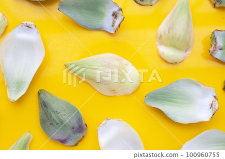 Fresh artichoke petals on yellow background 100960755