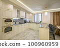 Cream colored classic kitchen with island used as dining area in studio apartment 100960959