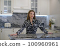Woman smiles in a kitchen with a timeless and elegant design 100960961