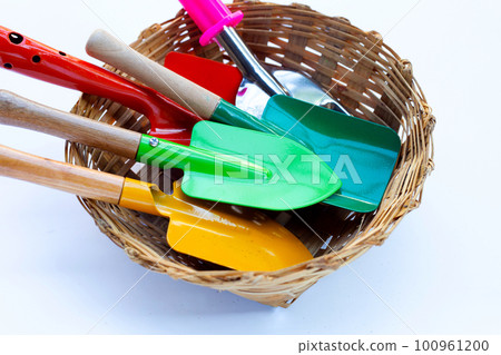 Garden shovel with fork in bamboo basket on white background. Garden tools Garden shovel with fork in bamboo basket on white background. Garden tools 100961200