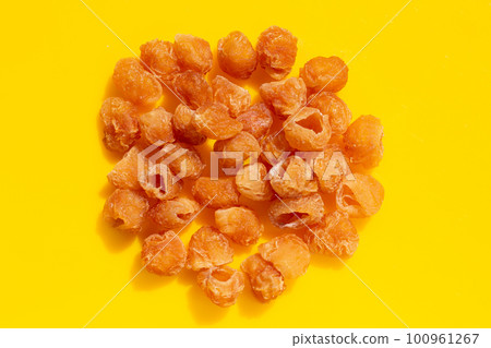 Dried longan on yellow background. 100961267