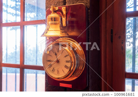 A golden clock shining in the sunlight by the window A golden clock shining in the sunlight by the window 100961681
