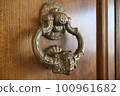 Antique doorknob attached to a wooden door 100961682