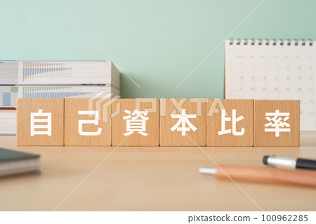 A desk with a block written as capital adequacy ratio 100962285