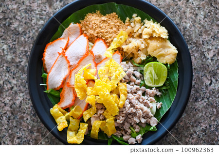 yellow noodles Thai food - dried noodles food on plate with condiment minced pork lemon lime peanuts dumpling red pork on plate yellow noodles Thai food - dried noodles food on plate with condiment minced pork lemon lime peanuts dumpling red pork on plate 100962363