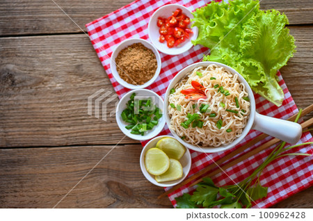 noodles bowl with vegetable spring onion lemon lime lettuce celery and chili on table food , instant noodles cooking tasty eating with bowl - noodle soup 100962428