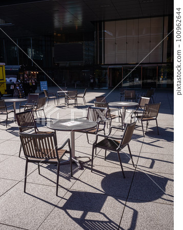 [Japan] Unmanned round tables and chairs lined up in a square in front of an office building in Tokyo 100962644