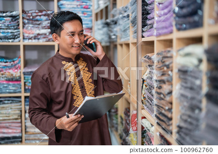 worker checking the product of his shop while receiving order worker checking the product of his shop while receiving order 100962760