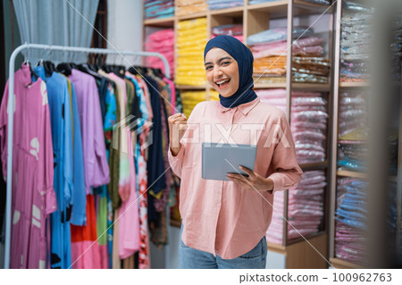 excited muslim owner of fashion store raise her arm excited muslim owner of fashion store raise her arm 100962763