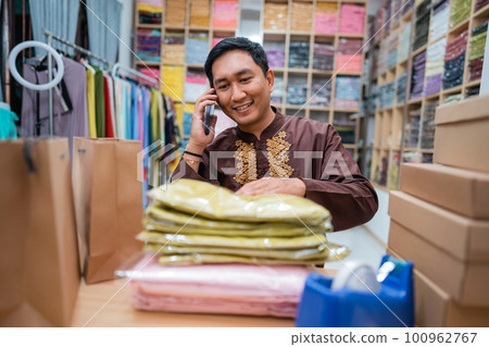 man owner having a phone call while checking the product man owner having a phone call while checking the product 100962767