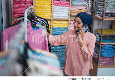 owner having a phone call while checking her fashion product owner having a phone call while checking her fashion product 100962770