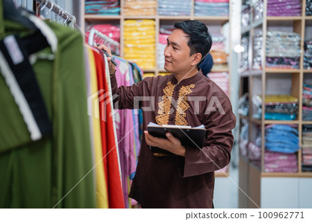 worker checking the product of his shop holding a note 100962771