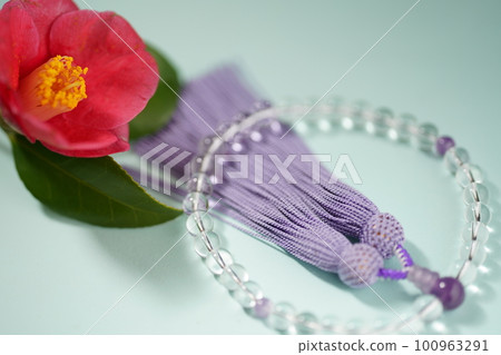 Red sasanqua flower and rosary 100963291