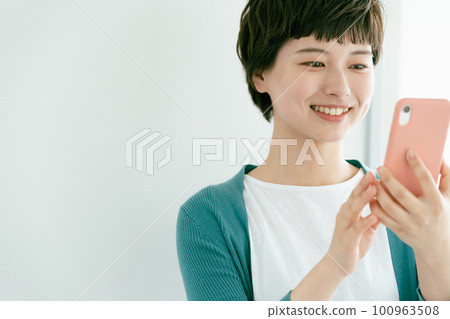 A young woman using a smartphone A young woman using a smartphone 100963508