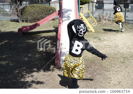 Villain girl playing on playground equipment in the park Villain girl playing on playground equipment in the park 100963734