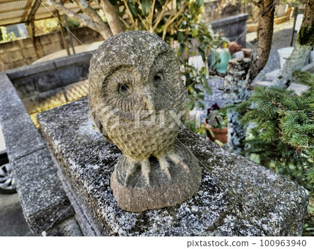 A stone owl figurine placed on the gatepost A stone owl figurine placed on the gatepost 100963940