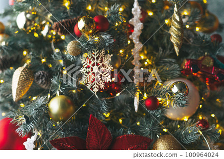 Decorated Christmas tree in golden and red toys with the lights bokeh textured background 100964024