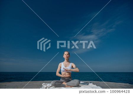 Yoga practice and meditation in nature. Woman practicing near Black sea. Yoga practice and meditation in nature. Woman practicing near Black sea. 100964428