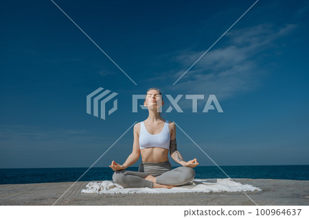 Yoga practice and meditation in nature. Woman practicing near Black sea. Yoga practice and meditation in nature. Woman practicing near Black sea. 100964637