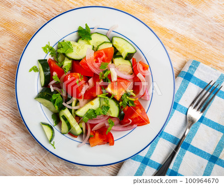 Delicious summer salad of cucumbers and tomatoes on plate Delicious summer salad of cucumbers and tomatoes on plate 100964670