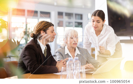 Adult man, elderly and young women having meeting in office Adult man, elderly and young women having meeting in office 100965054
