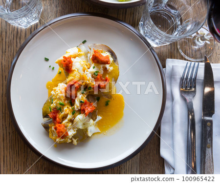 Ember-baked potato with spicy sausage pate and eggs, at plate 100965422