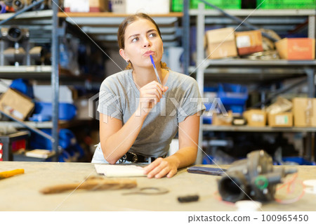 Portrait of thoughtful young woman worker checking order list Portrait of thoughtful young woman worker checking order list 100965450