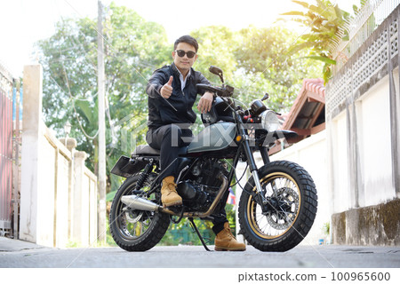 Asian man motorbike in black leather jacket travel rider trip. Handsome Men wear sunglass outdoor lifestyle freedom rider. Men trendy hipster cool person. Young asian man hobby ride with motor bike Asian man motorbike in black leather jacket travel rider trip. Handsome Men wear sunglass outdoor lifestyle freedom rider. Men trendy hipster cool person. Young asian man hobby ride with motor bike 100965600