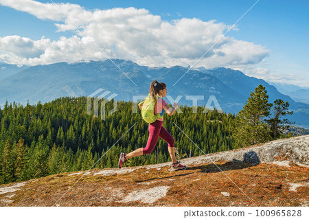 Running trail runner. Sport and fitness runner woman running cross-country trail run marathon training outside in mountains. Female athlete living healthy lifestyle. Squamish, British Columbia, Canada 100965828